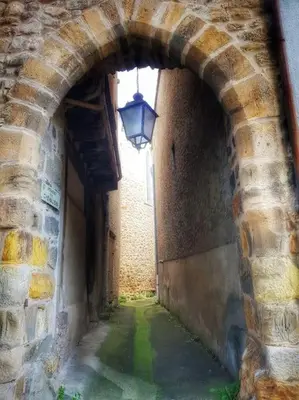 an alley with an archway with a light in a building at La maison des Chevaliers in Campagne-sur-Aude