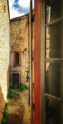 an open door to an alley with a building at La maison des Chevaliers in Campagne-sur-Aude