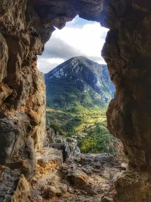 a view of a mountain through a rock window at La maison des Chevaliers in Campagne-sur-Aude