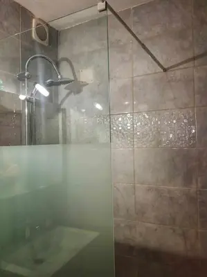 a bathroom with a glass shower with a sink at La maison des Chevaliers in Campagne-sur-Aude