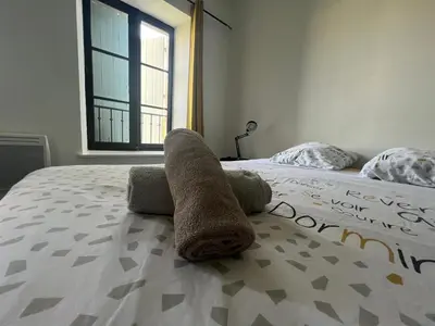 a towel laying on a bed in a bedroom at Le Bourgeois Grand T2 in Carcassone