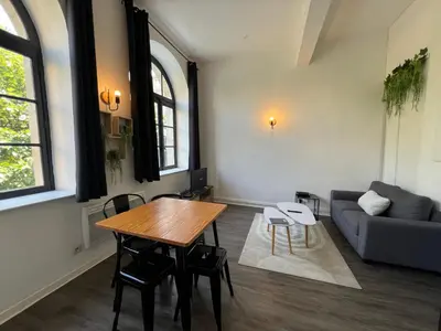 a living room with a table and a couch at Le Bourgeois Grand T2 in Carcassone