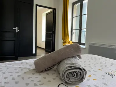 a towel laying on a bed in a bedroom at Le Bourgeois Grand T2 in Carcassone