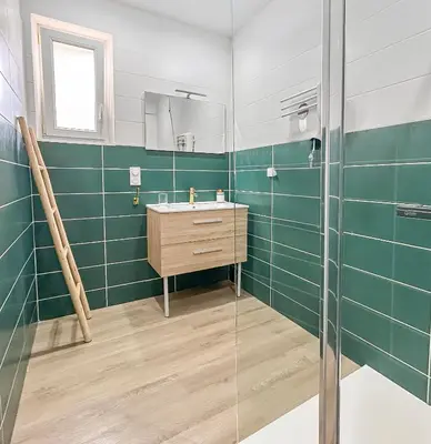 a bathroom with a sink and a glass shower at La Maison Rose - Proche Centre Ville in Narbonne