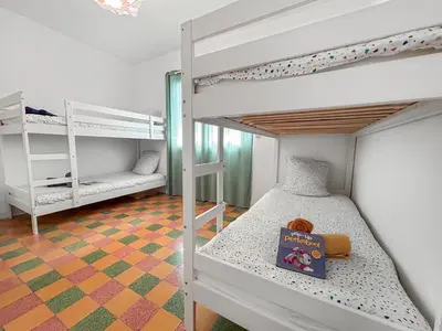 a bedroom with two bunk beds and a book at La Maison Rose - Proche Centre Ville in Narbonne