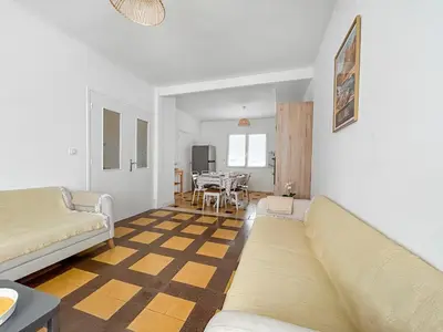 a living room with a couch and a table at La Maison Rose - Proche Centre Ville in Narbonne