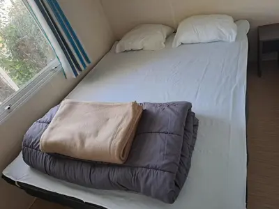 a bed in a small room with a pillow on it at mobile home 047 in Port-la-Nouvelle