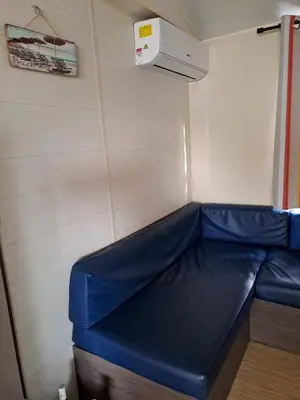 a blue couch in a room with a wall at mobile home 047 in Port-la-Nouvelle