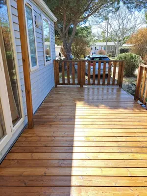 a wooden porch with a bench on a house at mobile home 047 in Port-la-Nouvelle
