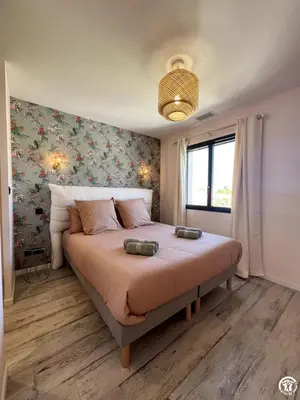 a bedroom with a large bed with a floral wall at Gite sainte louise in Narbonne