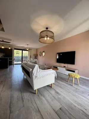 a living room with a couch and a flat screen tv at Gite sainte louise in Narbonne