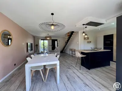 a kitchen and living room with a white table and chairs at Gite sainte louise in Narbonne