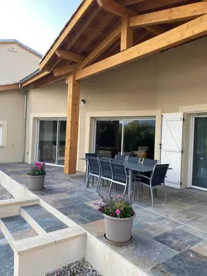 a patio with a table and chairs on it at Gite du tatou in Roquefeuil