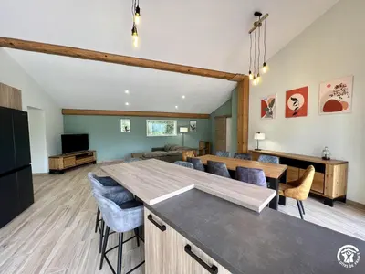 a kitchen and living room with a table and chairs at Gite du tatou in Roquefeuil