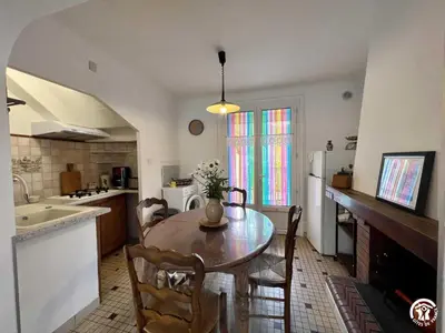 a kitchen with a table and chairs in a kitchen at La sapinette in Quillan