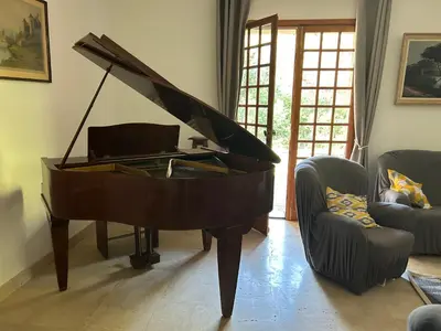 a piano in a living room with two chairs at Gîte les Mercieres la Villa Maison campagne grands espaces oasis de nature, convivialité, détente 5 Chambres piscine chauffée Wifi piano billard in Pexiora