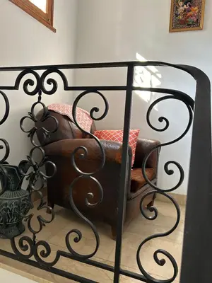 a black metal bed with a chair in a room at Gîte les Mercieres la Villa Maison campagne grands espaces oasis de nature, convivialité, détente 5 Chambres piscine chauffée Wifi piano billard in Pexiora