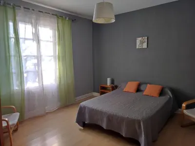a bedroom with a bed and a large window at Maison vigneronne in Ribaute