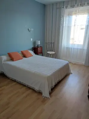 a bedroom with a large white bed and a window at Maison vigneronne in Ribaute