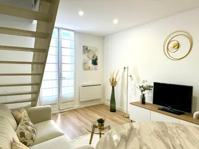 a living room with a table and a tv at Golden Duplex Chic - Centre-Clim-Parking in Narbonne