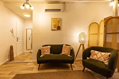 a living room with two chairs and a lamp at TerraCosy 2 personnes - Climatisé, Wifi, proche centre & restaurants in Narbonne