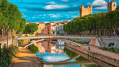 a bridge over a river with a boat under it at TerraCosy 2 personnes - Climatisé, Wifi, proche centre & restaurants in Narbonne