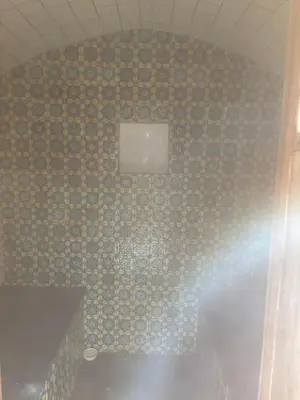 a bathroom with a tiled wall with a window at Fount Estremiero Apartment wellness and pool shared with B&B in Castans