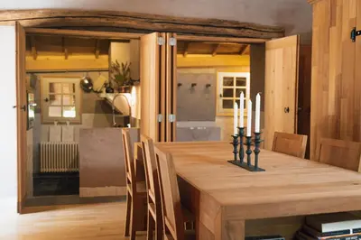 a dining room with a wooden table with candles at Fount Estremiero Apartment wellness and pool shared with B&B in Castans
