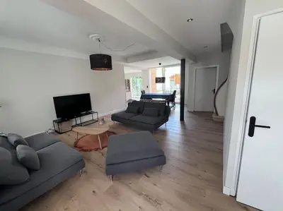a living room with two couches and a television at Maison climatisée, piscine, à 5 minutes des Grands Buffets in Narbonne