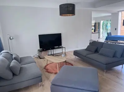 a living room with two couches and a tv at Maison climatisée, piscine, à 5 minutes des Grands Buffets in Narbonne