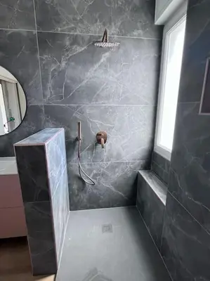 a bathroom with a shower with a stone wall at Maison climatisée, piscine, à 5 minutes des Grands Buffets in Narbonne