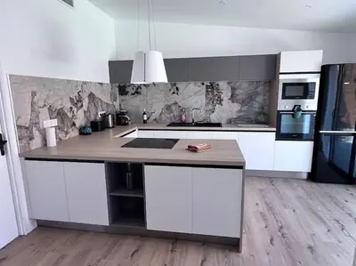a kitchen with white cabinets and a counter top at Maison climatisée, piscine, à 5 minutes des Grands Buffets in Narbonne