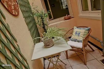 a chair and a table with a potted plant on a balcony at Oustal de Papé le calme au cœur de Mirepoix in Mirepoix