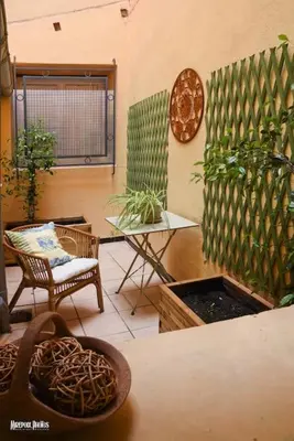 a room with a chair and a table with plants at Oustal de Papé le calme au cœur de Mirepoix in Mirepoix
