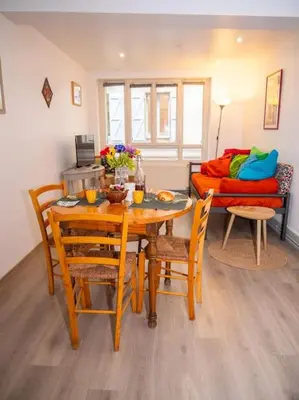 a dining room with a table and chairs and a couch at Oustal de Papé le calme au cœur de Mirepoix in Mirepoix