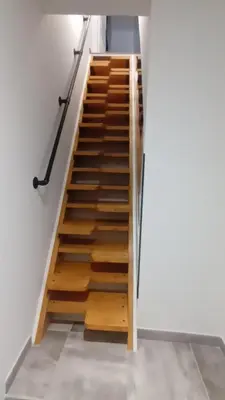 a staircase with wooden steps in a room at Appartement calme in Salses-le-Chateau