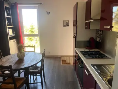 a kitchen with a wooden table and a table and a window at Gîte Appartement à la campagne in Lautrec