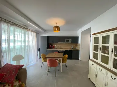a kitchen and living room with a table and chairs at Très beau F2 neuf 50 M2 , grande terrasse 30 M2, très bien situé in Narbonne
