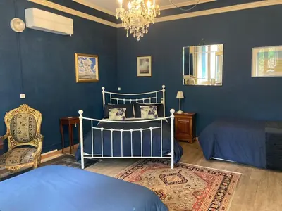 a blue bedroom with a bed and a chair at La Villa Celine in Saint-Laurent-de-la-Cabrerisse