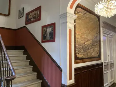 a hallway with a staircase with a painting on the wall at La Villa Celine in Saint-Laurent-de-la-Cabrerisse