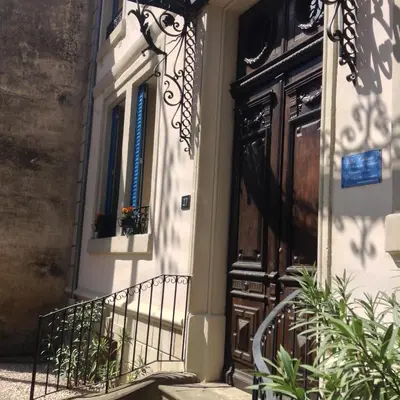 a building with a door and a balcony at La Villa Celine in Saint-Laurent-de-la-Cabrerisse