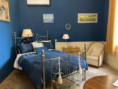 a blue bedroom with a bed and a chair at La Villa Celine in Saint-Laurent-de-la-Cabrerisse