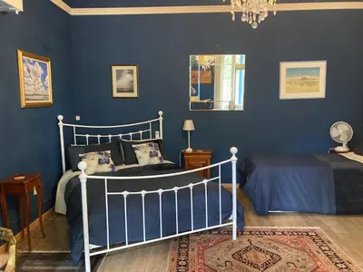 a blue bedroom with a bed and a mirror at La Villa Celine in Saint-Laurent-de-la-Cabrerisse