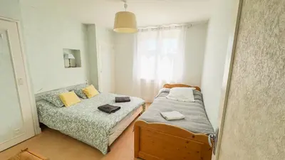 a small bedroom with two beds and a window at Gîte Familial du Vintrou in Le Vintrou