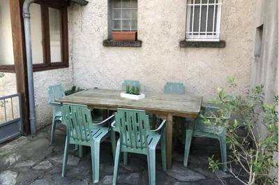 a wooden table and chairs outside of a building at Gîte Familial du Vintrou in Le Vintrou