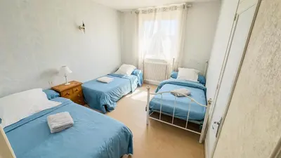 a room with two beds and a window at Gîte Familial du Vintrou in Le Vintrou