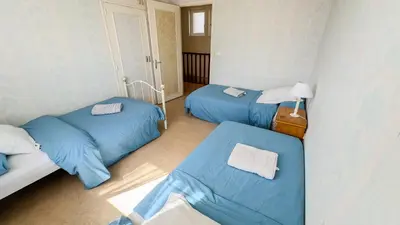 two beds in a room with blue sheets at Gîte Familial du Vintrou in Le Vintrou