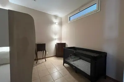 a bedroom with a bed and a window and a table at Ostau Agradiu - Maison de maître proche de la Mer in Peyriac-de-Mer