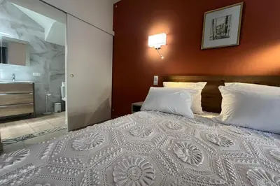 a bedroom with a large bed and a bathroom at Ostau Agradiu - Maison de maître proche de la Mer in Peyriac-de-Mer