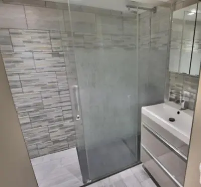 a bathroom with a glass shower and a sink at Studio Goya climatisé et jardin 2 nuits minimum in Castres